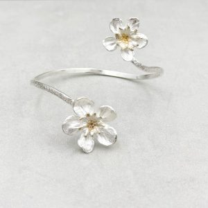 Geschwungener, handgefertigter Armreif mit Kirschblüten aus 925/-Silber, teilweise rosévergoldet. Durch die geschwungene, offene Form, sitzt der Armreif immer gut am Arm.