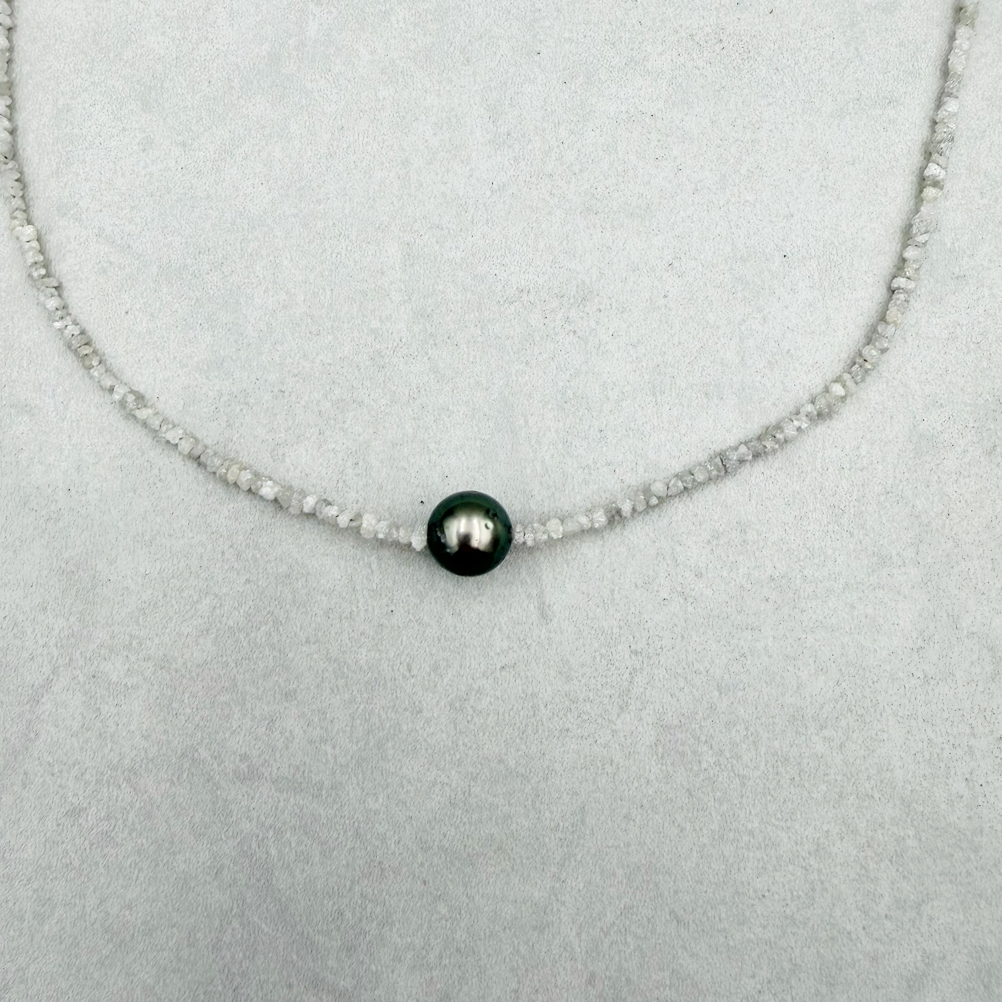 Ein zartes Glitzern wie Salzwasser und Sand auf der Haut. Elegant, zeitlos und dezent, aber dennoch luxuriös: eine einzelne edle dunkelgrau-schwarze Tahiti Perle, kombiniert mit einer zarten Kette aus gebohrten Rohdiamanten. Dieser Halsschmuck ist das perfekte Quiet-Luxury-Piece. Gesamtlänge: 43cm Tahiti-Perle: ca. 9,5mm Verschluss: Carabiner 585/-Gelbgold