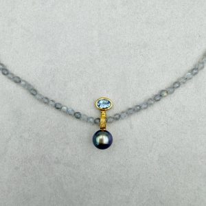 Anhänger aus 585/-Gelbgold mit einer dunkelgrau-schwarzen Tahiti-Perle (ca. 7.5-8.5mm) und einem ovalen Aquamarin (ca. 6x4mm), kombiniert mit einer funkelnden Labradorith Kette. Gesamtlänge: 44.5cm