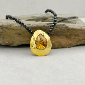 Anhänger aus 585/-Gelbgold mit gehämmerter, polierter Oberfläche und einem mattgelben Citrin im Fantasieschliff, kombiniert mit einer Kette von schwarzem, funkelndem Onyx. Gesamtlänge: 45cm Anhänger: ca. 3x2cm
